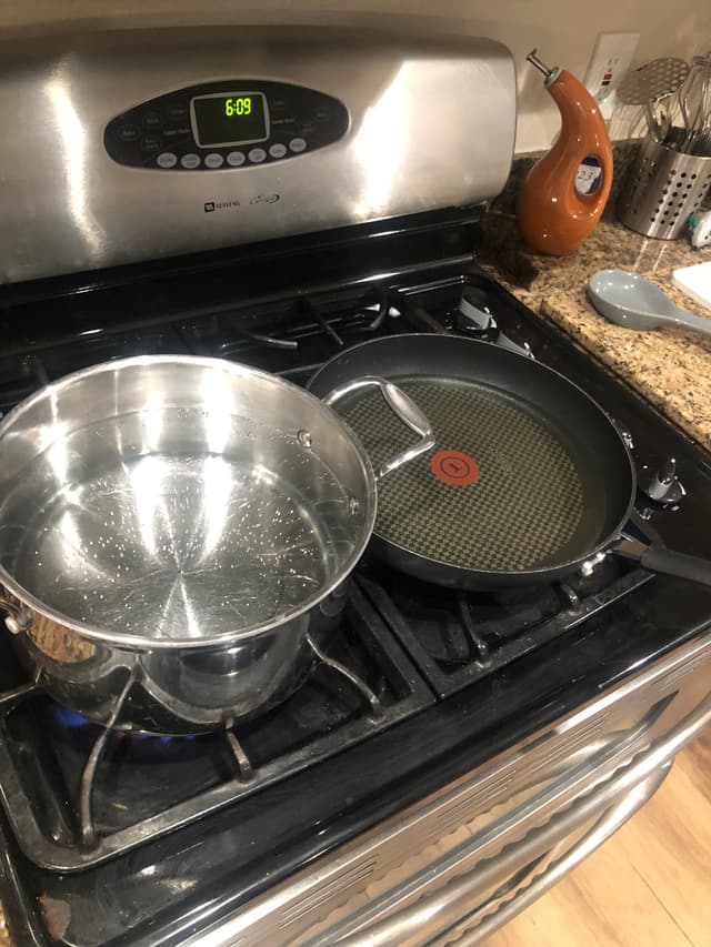 A pot of water and frying pan of oil coming up to temperature